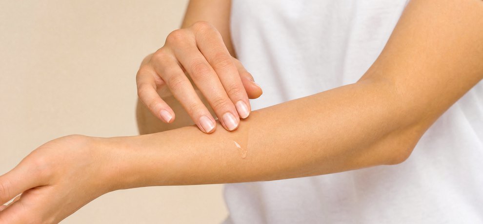 Application d'une huile apaisante sur l'avant-bras pour calmer la peau apres un contact avec une chenille processionnaire