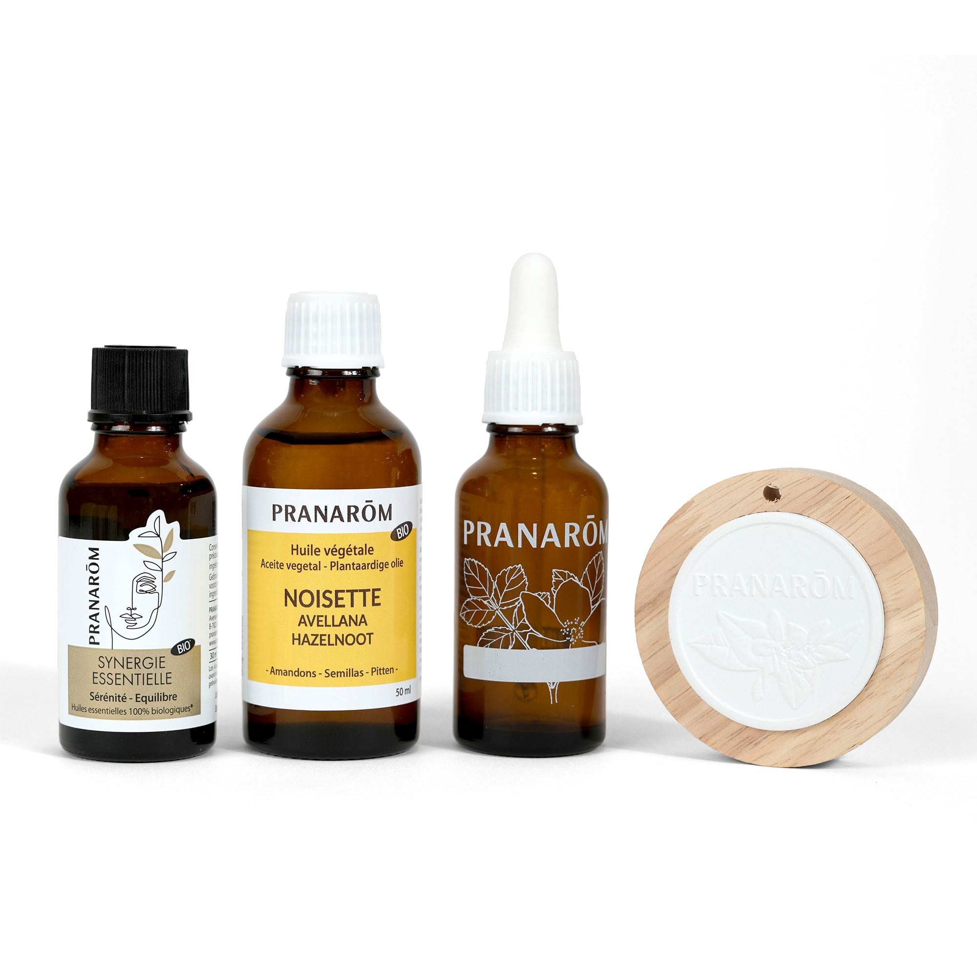Composition Pranarôm avec synergie essentielle, huile de noisette et un diffuseur en bois.