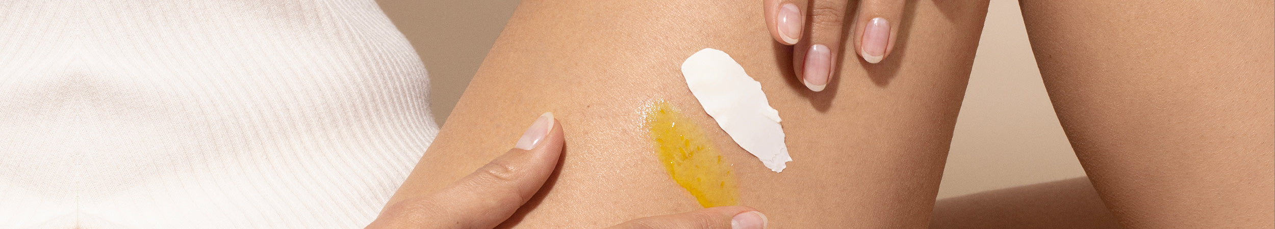 Application de deux texture : un gel doré et une crème blanche étalés sur la cuisse.