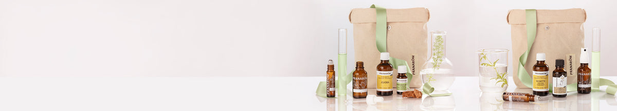 Bannière avec différents produits de coffrets Pranarōm : contenants et huiles végétales de jojoba.
